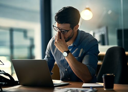 Shot of a young businessman experiencing stress during a late night at work